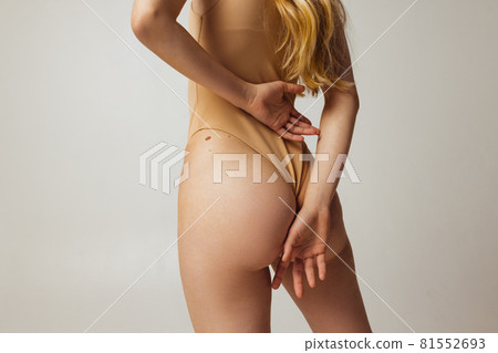 Back view of young beautiful slim tanned woman in lingerie posing isolated over light studio background. Natural beauty, wellness, healthy lifestyle concept. Back view of young beautiful slim tanned woman in lingerie posing isolated over light studio background. Natural beauty, wellness, healthy lifestyle concept. 81552693