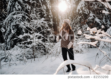 A girl in a sweater and glasses in winter in a snow-covered forest A girl in a sweater and glasses in winter in a snow-covered forest 81553200