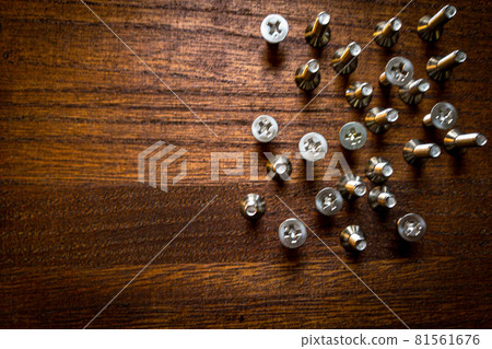 Countersunk screws lined up randomly on a brown wood table Countersunk screws lined up randomly on a brown wood table 81561676