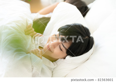 Mother and child waking up in bed 81563601
