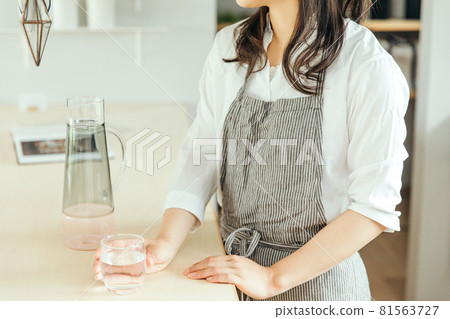 Woman holding a glass of water in the kitchen woman water hand Woman holding a glass of water in the kitchen woman water hand 81563727