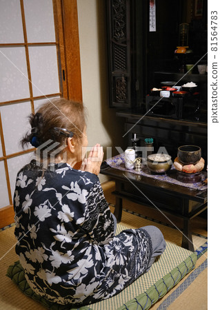 Elderly woman holding hands toward the Buddhist altar Back view Elderly woman holding hands toward the Buddhist altar Back view 81564783