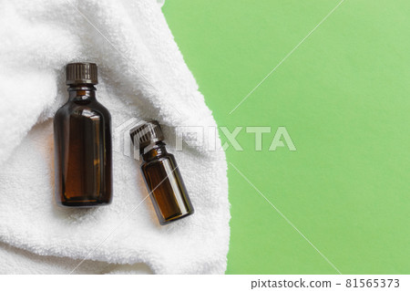 2 jars of brown glass with oil lie on a white towel 2 jars of brown glass with oil lie on a white towel 81565373