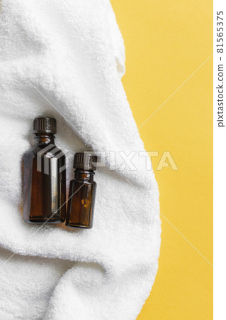 2 jars of brown glass with oil lie on a white towel 2 jars of brown glass with oil lie on a white towel 81565375