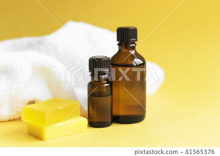 2 jars of brown glass with oil, soap, white towel lie on a yellow background 2 jars of brown glass with oil, soap, white towel lie on a yellow background 81565376