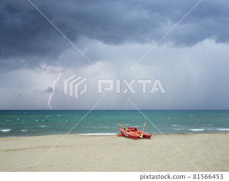 Storm on the beach, lightning falls into the sea 81566453