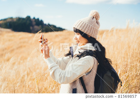 A woman taking a picture of a pampas grass field A woman taking a picture of a pampas grass field 81569857