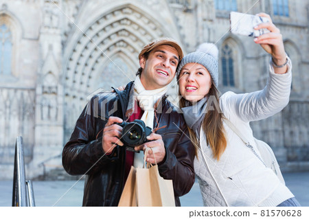 Couple man and woman in the historic center with camera and phone Couple man and woman in the historic center with camera and phone 81570628