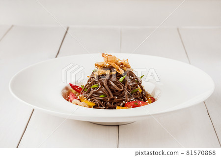 Soba noodles of buckwheat Noodles of buckwheat yellow pepper, tomato and herbs. Pan-Asian cuisine. Place for text. Square photo size. Soba noodles of buckwheat Noodles of buckwheat yellow pepper, tomato and herbs. Pan-Asian cuisine. Place for text. Square photo size. 81570868
