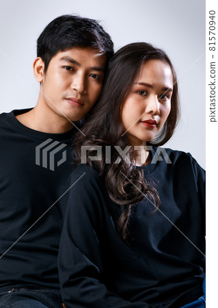 Young attractive Asian couple wearing black shirt and jeans against white background. Concept for pre wedding photography. Isolated Young attractive Asian couple wearing black shirt and jeans against white background. Concept for pre wedding photography. Isolated 81570940