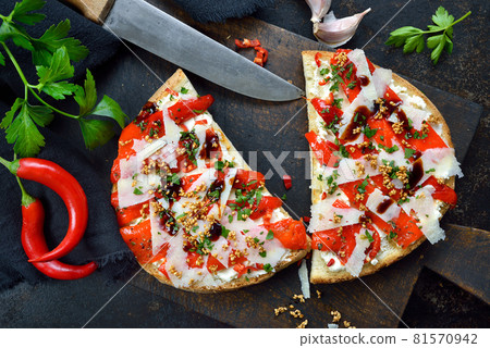 Italian large bruschetta with grilled pointed peppers, chili, pecorino, sesame and cream cheese Italian large bruschetta with grilled pointed peppers, chili, pecorino, sesame and cream cheese 81570942