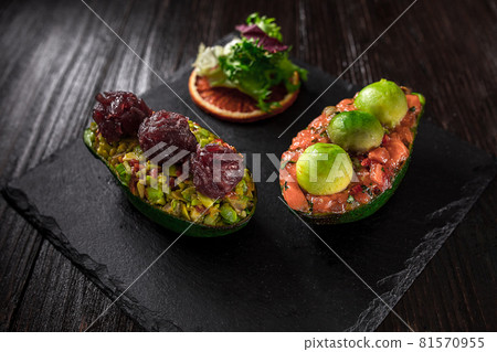 Salmon tartare and avocado salad on a black background Salmon tartare and avocado salad on a black background 81570955
