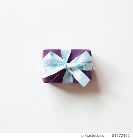 Purple gift box with blue ribbon isolated on white background. top view, copy space 81572421