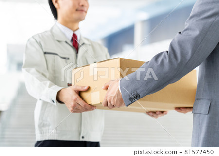 A man in work clothes delivering luggage to the office 81572450