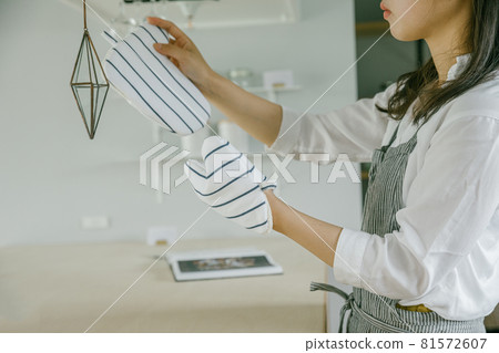 A woman wearing a mittens in the kitchen Kitchen woman A woman wearing a mittens in the kitchen Kitchen woman 81572607