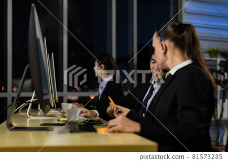 Businessman talking with team and working overtime late at night in call center office. 81573285