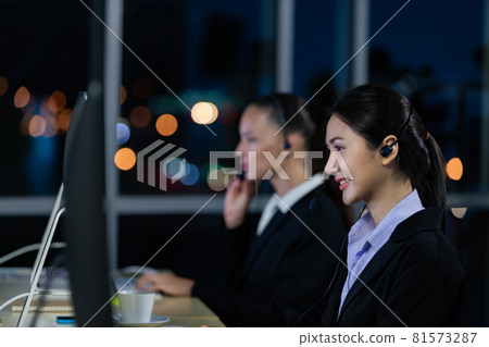 Asian young woman working overtime with her colleague team. 81573287