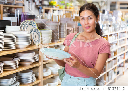 Asian woman choosing dishes at decor store 81573442