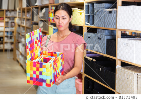 Asian Woman buying wicker fabric box at hardware store 81573495