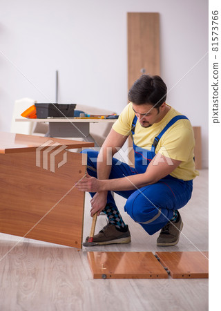 Young male carpenter repairing desk in the office 81573766