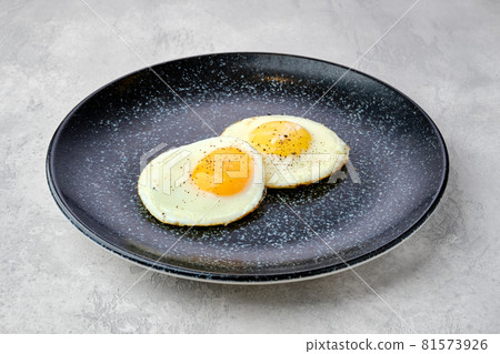 Two fried eggs on a plate. 81573926