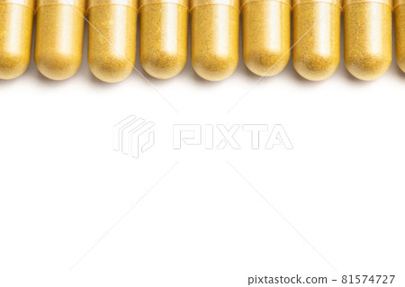 row of orange color organic capsules isolated on white background closeup with selective focus row of orange color organic capsules isolated on white background closeup with selective focus 81574727
