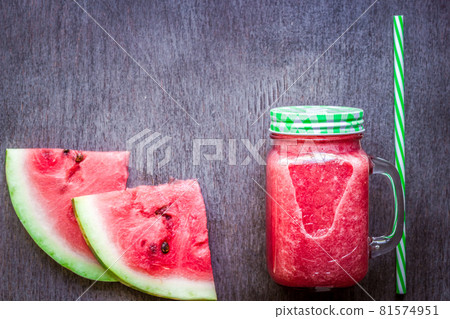 Watermelon smoothie and slices on dark wooden background. Flat lay or top view. 81574951