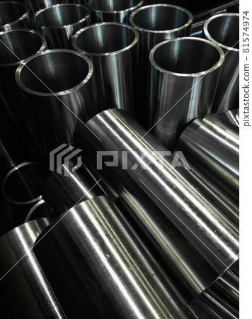dark industrial background with cnc machined shiny steel pipes - selective focus and lens blur tech 81574974