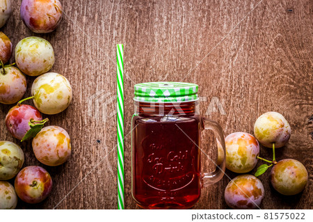 Glass with fresh Plum Juice on vintage wooden background 81575022