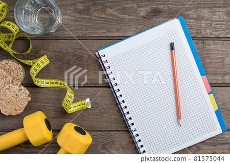 Glass of water with vegetables and measuring tape on table close-up Glass of water with vegetables and measuring tape on table close-up 81575044