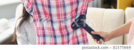 Seamstress ironing shirt with steamer in atelier closeup 81575669