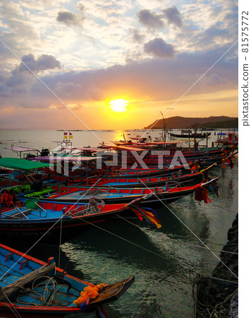 Wooden boat moored in shallow water near the beach at sunset. Romantic landscape. 81575772
