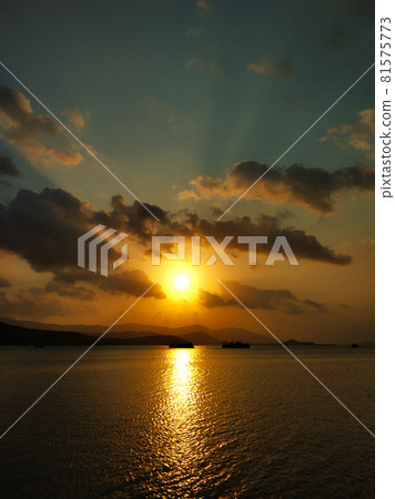 Fiery sunset with clouds by the ocean 81575773