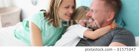 Young couple with little girl lying in bed Young couple with little girl lying in bed 81575847