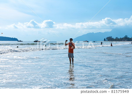 happy tourist guy on the central beach in Langkawi tropical island happy tourist guy on the central beach in Langkawi tropical island 81575949