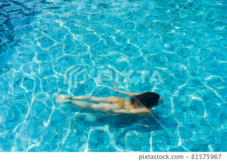 The girl dives under the water in the pool 81575967