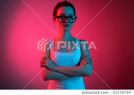 Woman boss. Cropped portrait of young beautiful girl in glasses on gradient pink red background 81576744