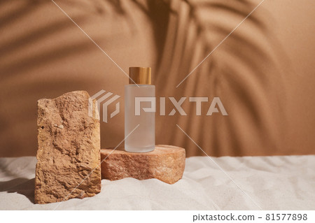 Minimal background for product presentation. Serum bottle and podium on sand beach with sunshade and shadow on the background Minimal background for product presentation. Serum bottle and podium on sand beach with sunshade and shadow on the background 81577898