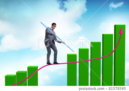Businessman walking on tight rope between bar chart Businessman walking on tight rope between bar chart 81578595