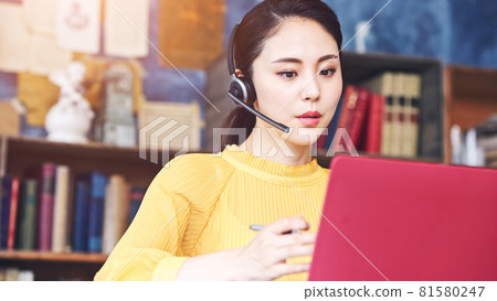 A woman talking with a headset Video conference Videophone A woman talking with a headset Video conference Videophone 81580247