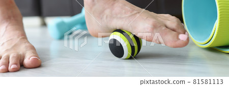 Woman does exercises with ball to correct foot defects and flat feet Woman does exercises with ball to correct foot defects and flat feet 81581113