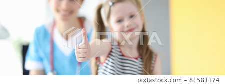 Little girl showing thumb up at doctor appointment closeup Little girl showing thumb up at doctor appointment closeup 81581174
