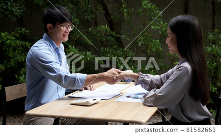 Working outdoor concept a female freelancer handshaking with a male customer to cooperate with the new business. 81582661