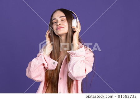 Cropped portrait of young beautiful woman listening to music in headphones Cropped portrait of young beautiful woman listening to music in headphones 81582732