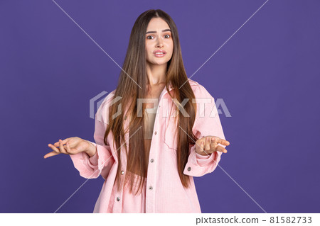 Cropped portrait of young beautiful woman gesturing on purple background. Sarcastic feeling Cropped portrait of young beautiful woman gesturing on purple background. Sarcastic feeling 81582733