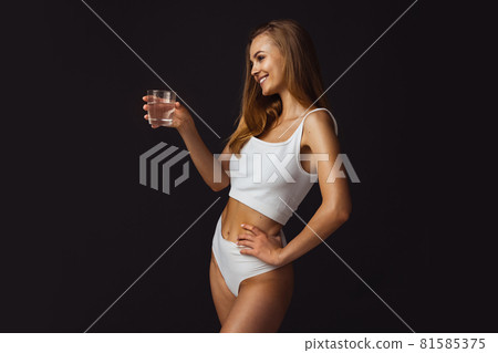 Cropped image of young beautiful caucasian girl on dark studio background 81585375