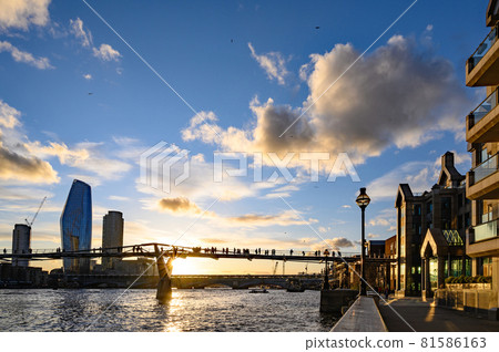 Sunset behind the Millennium Bridge in London, UK with dramatic clouds. It crosses the River Thames with Blackfriars Bridge and the South Bank behind 81586163