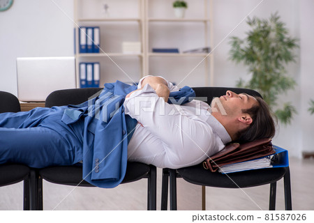 Young male employee sleeping in the office on chairs 81587026