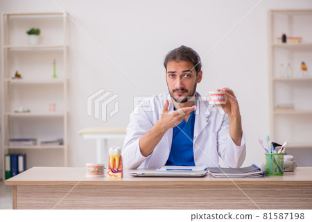 Young male dentist lecturer working in the clinic 81587198