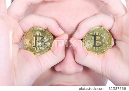 Man keeps the eye instead two golden cryptocurrency bitcoin in hands 81587366